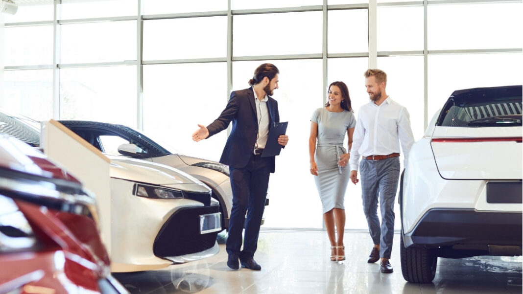 clientes mirando coches concesionario decisión compra coche nuevo